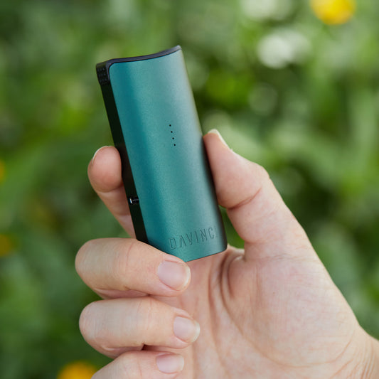 Green Miqro-C in mans hand outside.